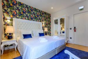 波尔蒂芒Villa Mariazinha Charming Hotel的卧室配有带蓝色枕头的大型白色床