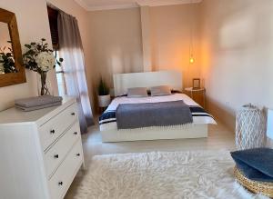 科马尔诺Apartmán Rea的一间卧室配有一张床和一个花瓶梳妆台