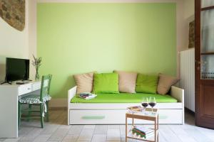 LarcianoAgriturismo La Casina nel Vigneto的客厅配有绿色沙发和桌子
