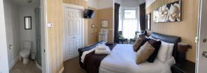 绍斯波特阿德尔菲旅馆的一间卧室配有带白色床单和枕头的床。