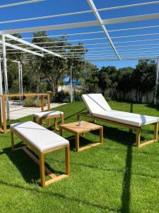 托雷桑塔萨宾娜Miramare Blue Stay的一群长凳和桌子在草地上