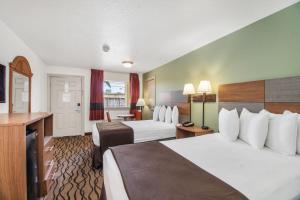 加尔维斯敦Motel 6 Galveston, TX Seawall的酒店客房配有两张床和一张书桌