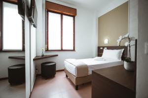 帕尔马诺瓦Albergo Commercio的配有一张床和一张书桌的酒店客房