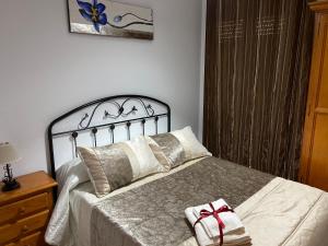 塞特尼尔Vivienda Rural Los Tajos de Setenil的一间卧室配有一张床,床上有一个圣诞弓