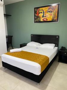 里奥阿查Hotel Diamonds的卧室内的一张床铺,墙上有绘画作品