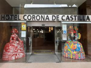 布尔戈斯Hotel Corona de Castilla Burgos的树冠旅馆窗户上的2个雕塑