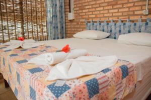 贝贝里比Ocas do Índio Hotel Spa的一张带白色毛巾和红色鲜花的床