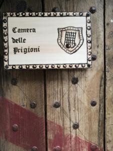 托迪Agriturismo Castello Di Belforte的木门上的标志,用来读书花园门的表皮