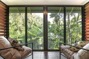 丹特里Daintree Ecolodge的客厅设有大型玻璃窗,享有森林美景
