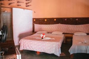 贝贝里比Ocas do Índio Hotel Spa的一间设有两张床的房间和一只猫坐在床上