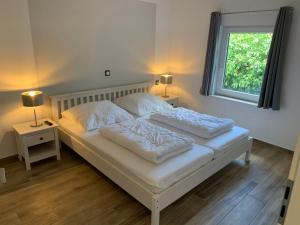卡尔斯哈根Quartier Usedom的卧室内的一张带两个枕头的白色床