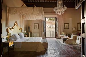 格拉纳达格拉纳达卡萨1800酒店的一间卧室配有一张床和一个吊灯