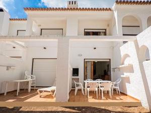 迈阿密普拉特亚Belvilla by OYO El Pinar的白色的房子,设有带桌椅的阳台