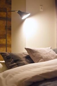 东京REGALO Shibaura - Vacation STAY 88351的卧室配有一张带墙上灯的床。