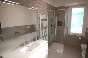 阿尔玛·迪·塔吉亚Persea mare appartamenti的一间带水槽和玻璃淋浴的浴室