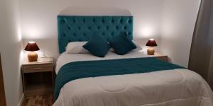 巴耶纳尔Cabañas Licanantay的一间卧室配有一张大床和蓝色床头板