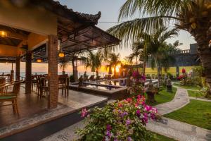 艾湄湾艾迈海滩度假酒店的餐厅享有海滩和棕榈树的景致