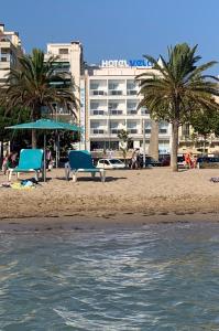 罗萨斯韦拉酒店的海滩上设有两把蓝色椅子,酒店