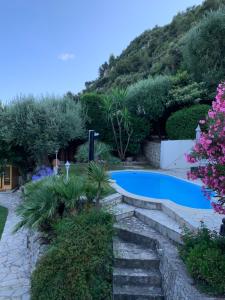拉蒂尔比耶Monte Carlo View and Spa的花园中的一个游泳池,花园内种有鲜花和树木