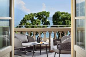 梅纳焦Grand Hotel Victoria concept & spa, by R Collection Hotels的客房设有带椅子和桌子的阳台。