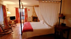 塞尔塞迪利亚纳瓦梅迪奥酒店的一间卧室配有一张天蓬床和一台电视机