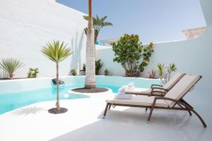 科拉雷侯Villa 44的一个带椅子和棕榈树的庭院和一个游泳池