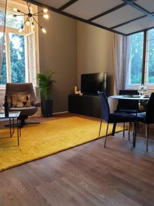 奥帕提亚Apartment Sea Promenade - Opatija center的客厅配有黄色地毯和桌椅
