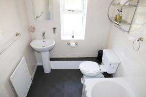比代尔爱玛菲尔德庄园酒店的白色的浴室设有卫生间和水槽。