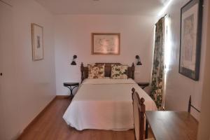 VilladepalosRestaurante - Hotel La Tronera的一间卧室配有一张床和一张桌子