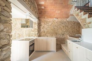 VilopríuFlateli Vilopriu的厨房配有白色橱柜和砖墙
