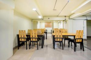 清迈OYO 928 Leaf Hostel的用餐室配有木桌和椅子