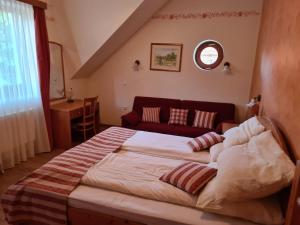 Ribnica na PohorjuApartmaji PEC-Sitar的一间卧室配有一张大床和一张红色的沙发