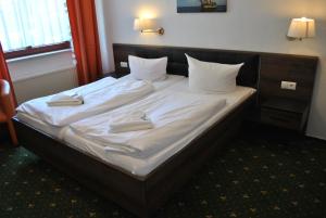 洛布洛贝斯特兰德酒店的一张带白色床单的床和两张毛巾