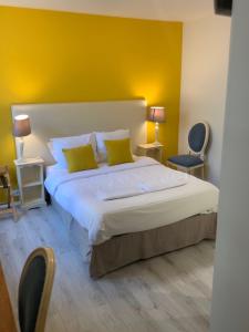 迪耶普格兰德杜克斯酒店的一间卧室设有一张黄色墙壁的大床