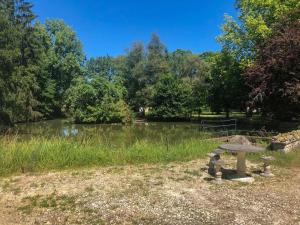 VaraignesL'étang des Mirandes的池塘旁公园的野餐桌