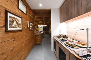 瓦托内切Hotel Rascard的一间带木墙的厨房和一个带食品的柜台
