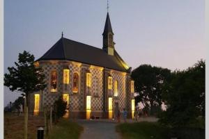 滨海卡约La cabine en Baie de Somme的一座带灯光的大型石头教堂