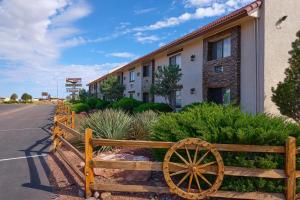 瓦莱Grand Canyon Inn and Motel - South Rim Entrance的建筑前的木栅栏,带木轮