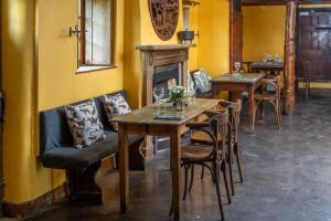 拉科克Rising Sun Pub, Restaurant and Rooms的一间带桌椅和壁炉的用餐室