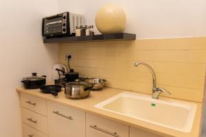 埃拉特סטודיו 10 studio的厨房配有水槽以及带锅碗瓢盆的炉灶。