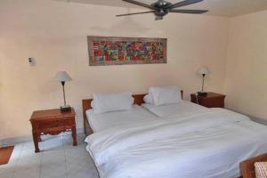登巴萨Nakula Familiar Inn的一间卧室配有两张床和吊扇