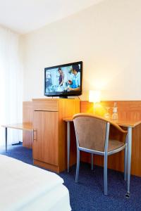 明斯特Haus Niemann的酒店客房配有电视、桌子和椅子