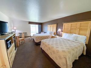 姊妹城Sisters Inn & Suites的酒店客房设有两张床和一台平面电视。