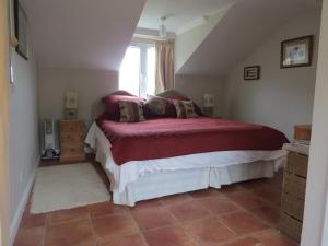HooeRosemary Cottage的一间卧室配有一张带红色毯子的床