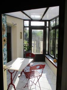 Vireux-MolhainGÏTE LE CONFLUENT的客房设有桌椅和窗户。