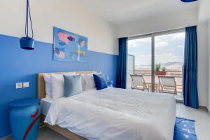 雅典Selina Athens Theatrou的一间卧室设有一张床和蓝色的墙壁