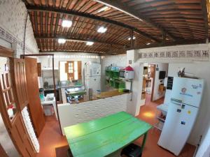 马拉戈日Maragogi Hostel的厨房配有绿桌和冰箱。