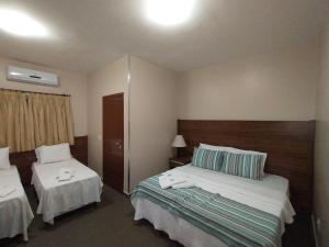 乌贝拉巴Hotel Albatroz的酒店客房,设有两张床和两张桌子