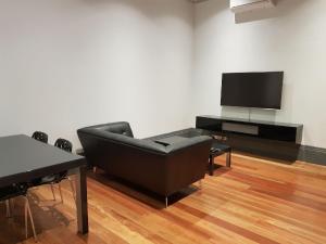 拉瑟格伦定制公寓的客厅配有黑色沙发和平面电视。