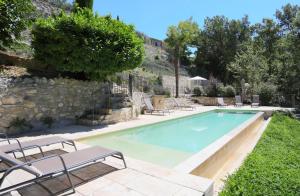 Saint-Martin-de-CastillonMas des Baussiers的一座带躺椅的游泳池,毗邻石墙